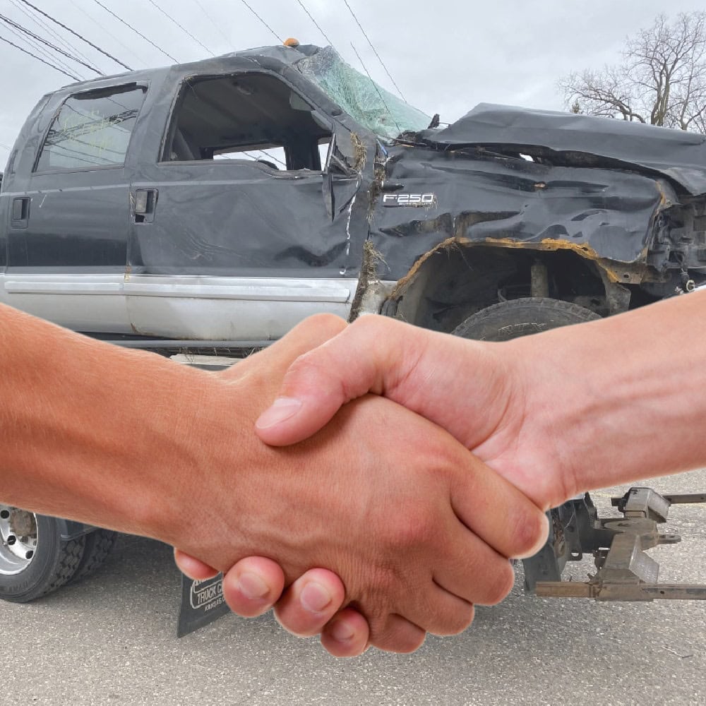 a handshake in front of a wrecked truck for Cash for Cars in MN
